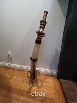 Buse de tuyau de jeu en laiton et caoutchouc vintage Larkin avec poignées en cuir. 34 po de hauteur.